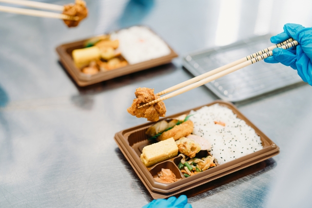 お弁当におかずを詰める作業員